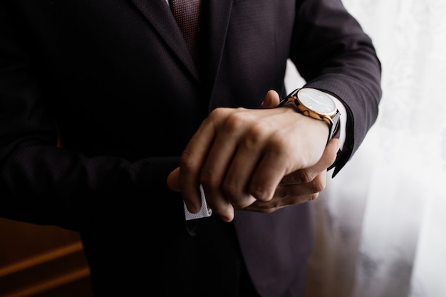 Photo gratuite l'homme met une montre à son poignet