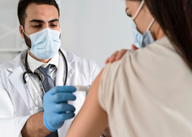 Homme mettant un bandage sur le bras d'un patient