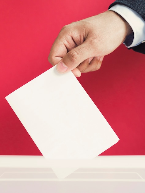 Homme mettant un bulletin de vote vide dans une boîte de maquette