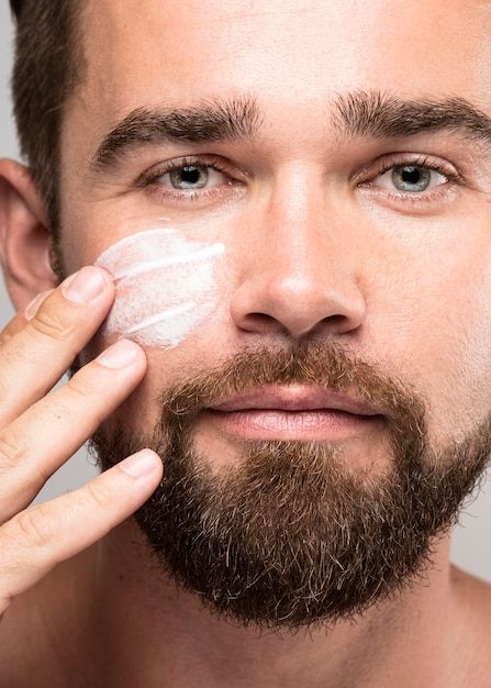 Photo gratuite homme mettant la crème pour le visage