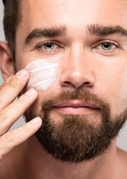 Homme mettant la crème pour le visage