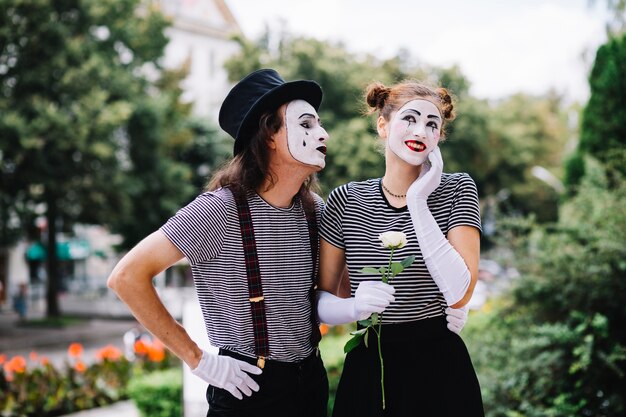 Homme mime regardant heureux mime féminin dans le parc