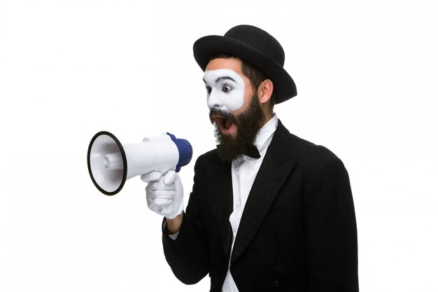 Homme avec un mime visage criant dans un mégaphone