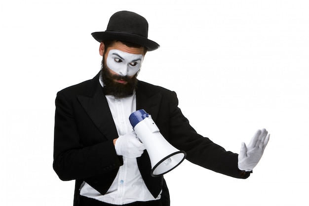 Homme avec un mime visage criant dans un mégaphone