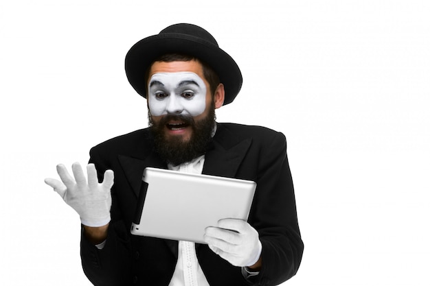 Homme avec un mime de visage travaillant sur ordinateur portable