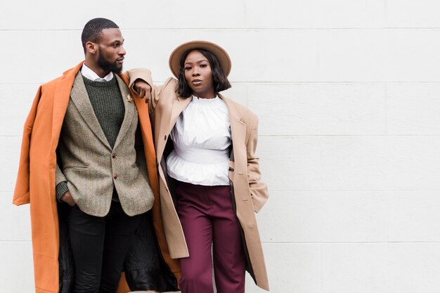 Homme à la mode et femme posant avec espace copie