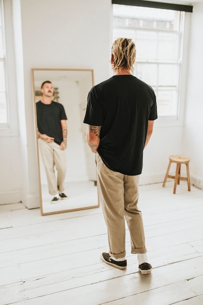 Photo gratuite homme à la mode se regardant dans le miroir