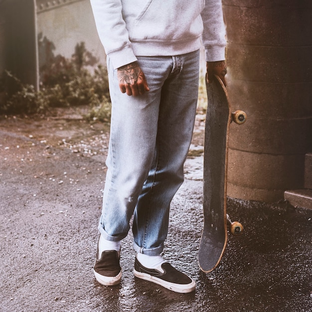 Photo gratuite homme de mode streetwear avec une planche à roulettes