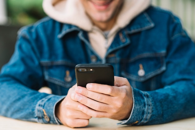 Homme moderne à l&#39;aide de smartphone en milieu urbain