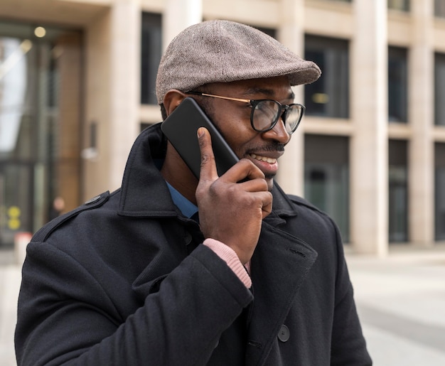 Homme moderne à l'aide de son téléphone à l'extérieur