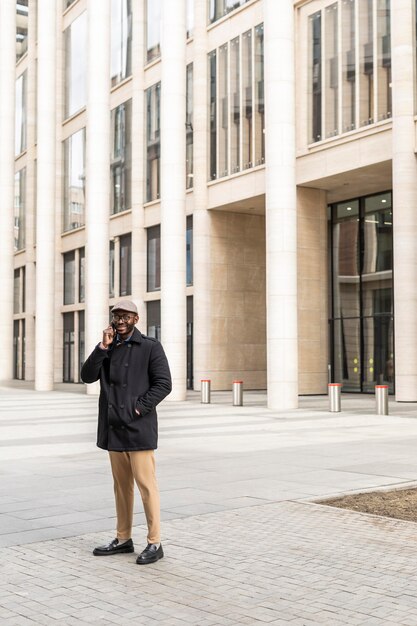 Homme moderne à l'aide de son téléphone à l'extérieur