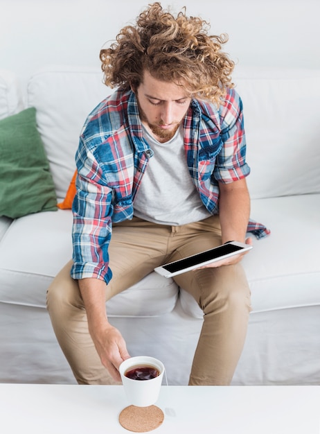 Photo gratuite homme moderne à l'aide d'une table sur un canapé