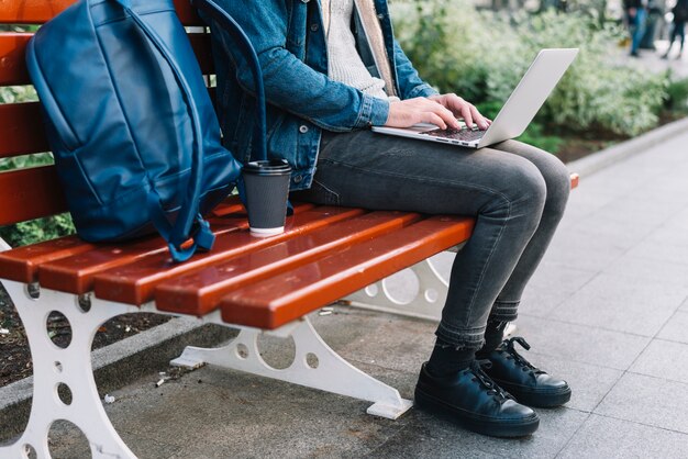 Homme moderne assis sur un banc en milieu urbain