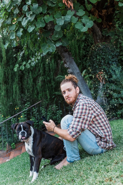 Homme moderne avec chien dans le jardin