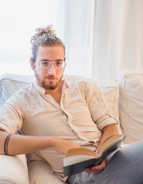 Homme moderne lisant sur un canapé