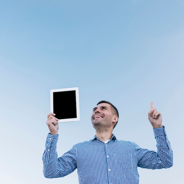 Homme moderne pointant vers le haut avec tablette