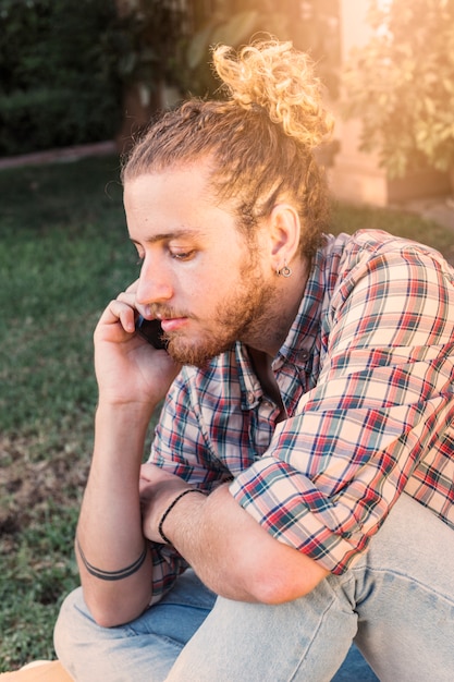 Photo gratuite homme moderne avec smartphone dans le jardin