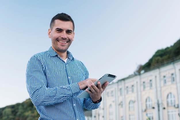 Homme moderne avec tablette en milieu urbain