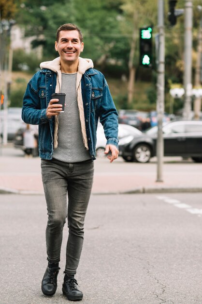 Homme moderne avec une tasse de café en milieu urbain