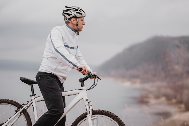 Homme monté sur un vélo par une journée froide et à l'écart avec copie espace