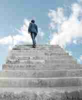 Photo gratuite l'homme à monter les escaliers vers le ciel