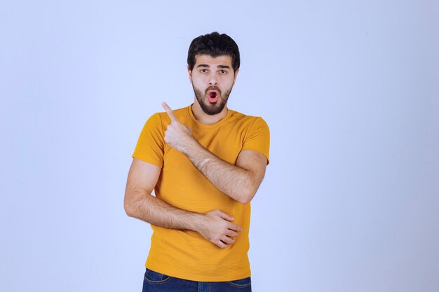 Homme montrant et pointant le côté gauche.