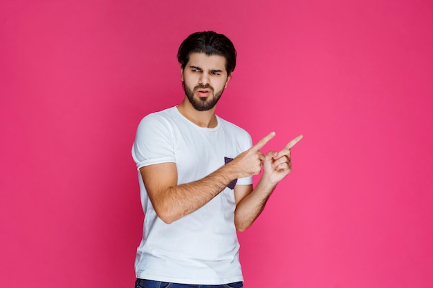 Homme montrant quelqu'un et quelque chose dans la droite.