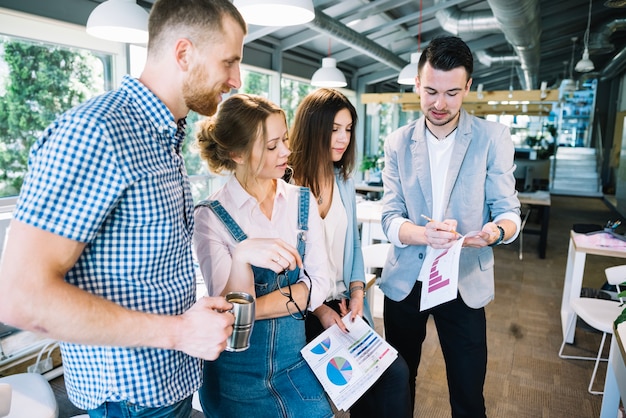 Homme montrant tableau aux employés