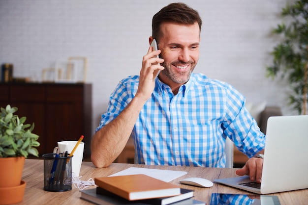 Homme multitâche travaillant dans son bureau