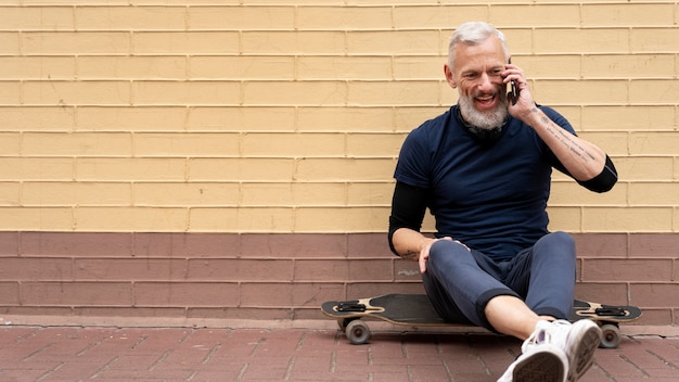 Homme mûr avec planche à roulettes de mobilité durable