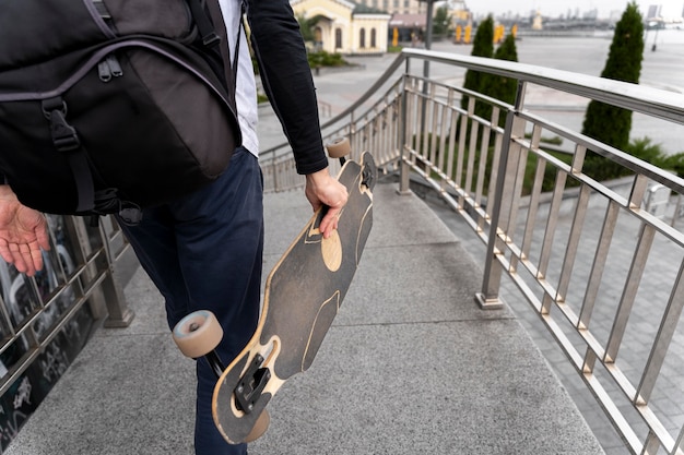 Homme mûr avec planche à roulettes de mobilité durable