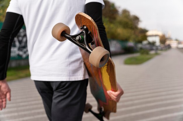 Homme mûr avec planche à roulettes de mobilité durable