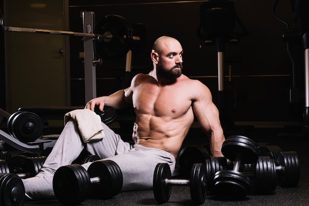 Photo gratuite homme musclé au milieu des haltères