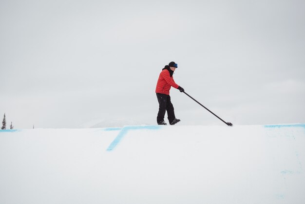 Homme, nettoyage de la neige dans la station de ski