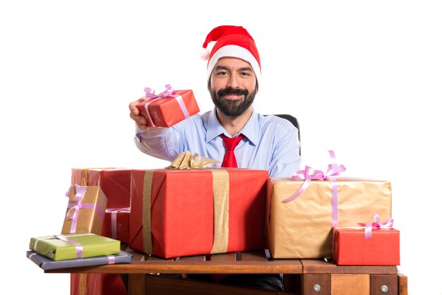 Homme de Noël dans son bureau avec plusieurs cadeaux