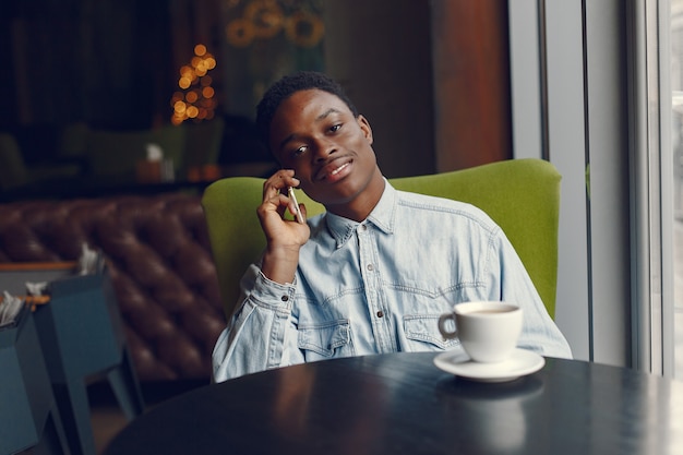 Homme noir assis dans un café et boire un café