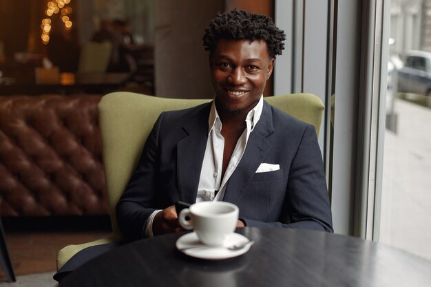 Homme noir assis dans un café et boire un café