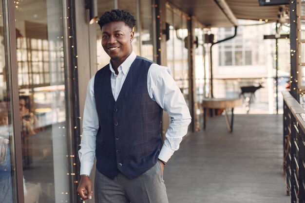 Homme noir dans une chemise bleue, debout dans un café