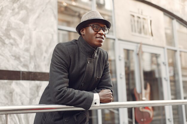 Homme noir dans un manteau noir dans une ville d'automne