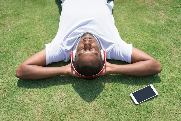 Photo gratuit homme noir détendu se reposer dans le parc et écouter de la musique.