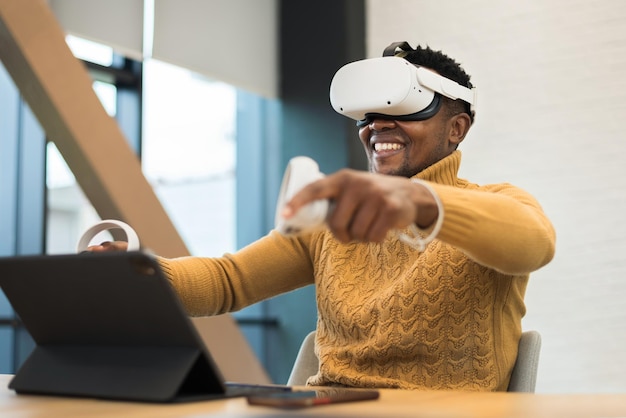 Un homme noir excité explorant la réalité virtuelle dans un bureau