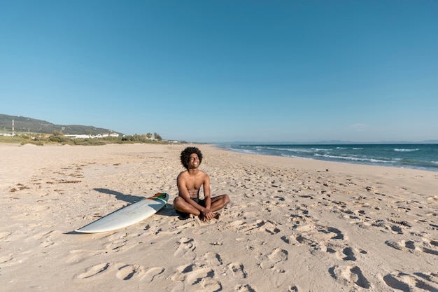 Photo gratuite homme noir souriant se détendre sur la plage