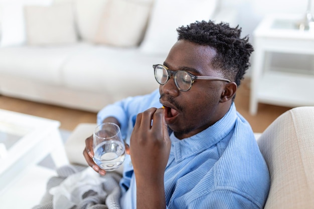 Photo gratuite un homme noir tient des pilules et un pot dans ses mains concept de soins de santé et de médecine le patient prend une dose quotidienne de médicament prescrit se sent malade antibiotiques analgésiques ou antidépresseurs gros plan