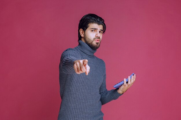 Homme avec un nouveau smartphone pointant vers le client.