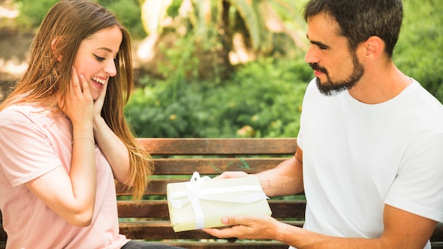 Homme offrant un cadeau à sa petite amie surprise