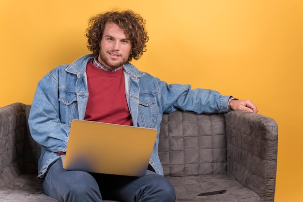 Photo gratuite homme avec ordinateur portable sur le canapé