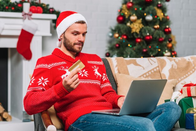 Homme avec ordinateur portable et carte plastique