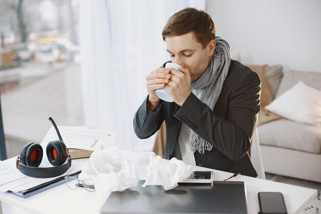 L'homme avec un ordinateur portable souffre de toux et se sent mal. Homme d'affaires à la maison.