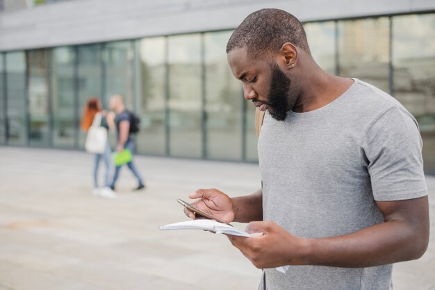 Homme avec papiers et smartphone