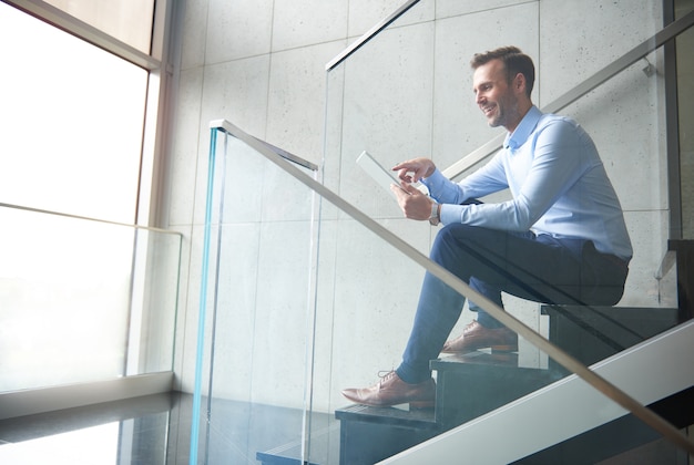 Homme parcourant la tablette numérique au bureau